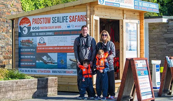 Family smiling dressed up and ready outside Padstow Sealife Safaris hut
