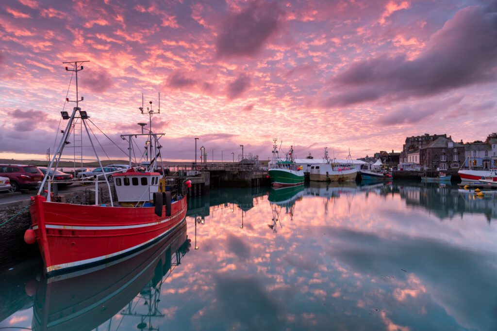 Beautiful sunrise over fishing boats in the harbour at Padstow in Cornwall